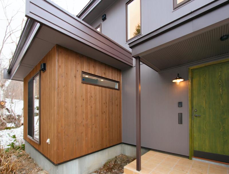 玄関、ドア、ポーチ・風除室：シックな色の羽目板と対象的なモスグリーン色の玄関ドアが印象的